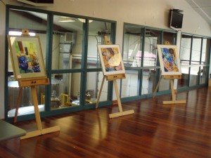 Paintings set up on easels.